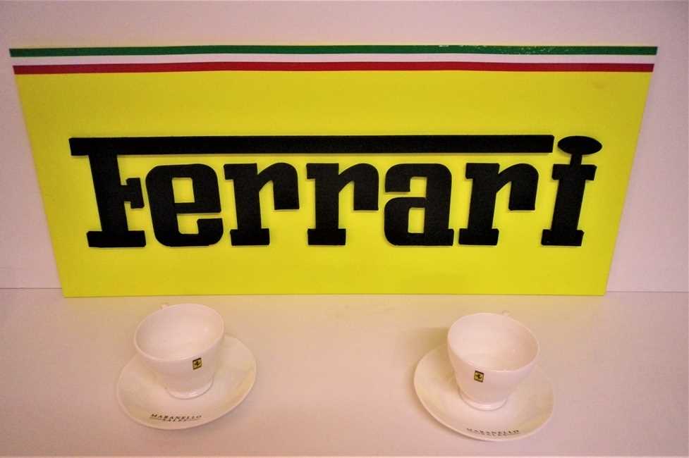 Click for high resolution Lot 21 - A Ferrari garage wall sign measuring 69x30cm, as well as two Ferrari cups and saucers