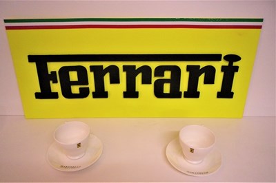 Lot 21 - A Ferrari garage wall sign measuring 69x30cm, as well as two Ferrari cups and saucers