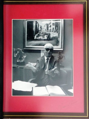 Lot 63 - A framed and glazed print showing Enzo Ferrari at his desk